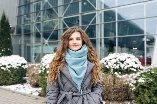 Attractive serious Face young woman looking at camera beautiful curly hair stand on street city lifestyle winter girl city outdoors