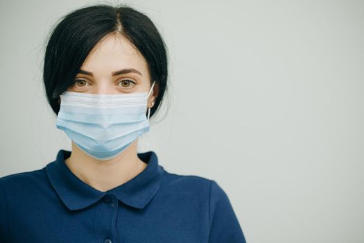 Young woman in medical mask. Female breathes deeply and looking at camera. Health care and medical concept. Close up portrait. Health Protection Corona Virus Concept