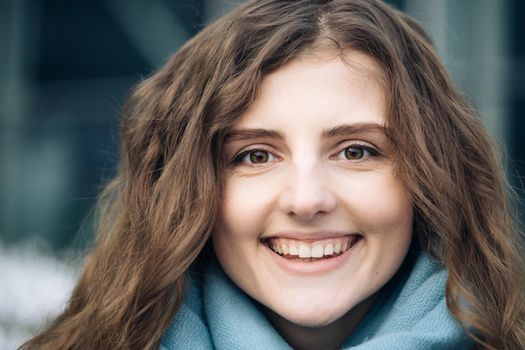 Face of beautiful woman with natural make-up looking at camera. Portrait young caucasian pretty curly hair girl outside. Etnnicity. People. Beauty. Happy Young Woman Enjoys Life