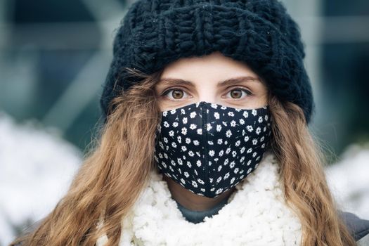 Young woman in medical face mask standing against city. COVID-19 Pandemic Coronavirus Woman in a city wearing face mask protective for spreading of disease virus SARS-CoV-2