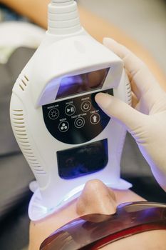 Dentist doing teeth whitening procedure with ultraviolet lamp. Concept of teeth care and dentistry. Teeth whitening using an ultraviolet lamp.