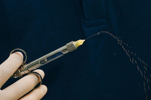 Dentist hand in glove holding syringe anesthesia. Close up of doctor holding syringe with dental anesthetic. Medicine, dentist, and health care concept.