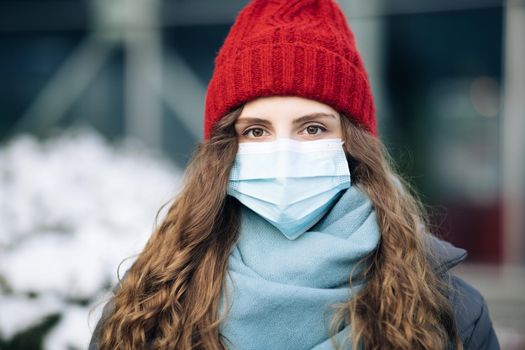 Pandemic coronavirus covid concept. Curly brunette woman in surgical protective mask for corona virus second outbreak prevention. Girl with protective mask on face.