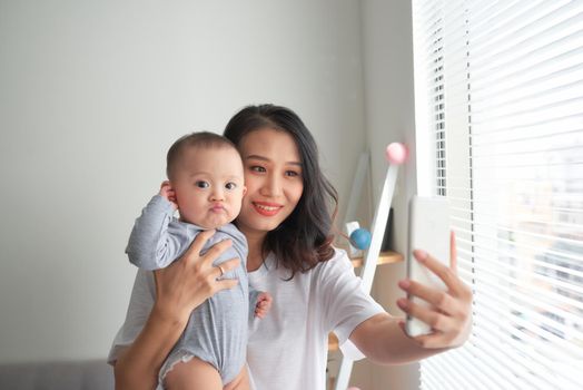 Woman with a baby doing a selfie 