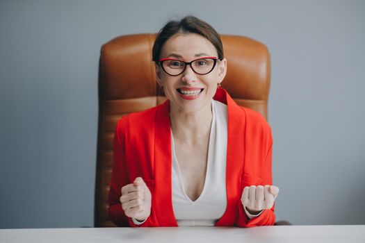 Cute girl holding her glasses and smiling. Beautiful happy businesswoman working at home office.