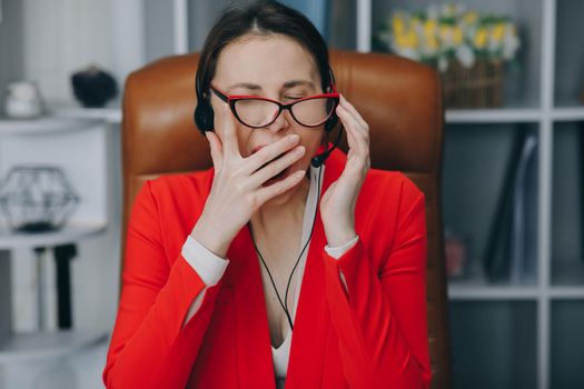 Call center operator is tired of talking to people asking stupid questions. Young customer service representative at work. Young female worker productively operating at call-centre.