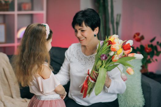 Hugging happy family. Happy Mother's Day. Little daughter congratulates her mother on Mother's Day.