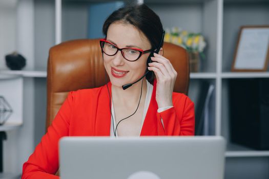 Happy young woman wear headset communicating by conference call speak looking at computer at home office. Video chat job interview or distance language course class with online teacher concept