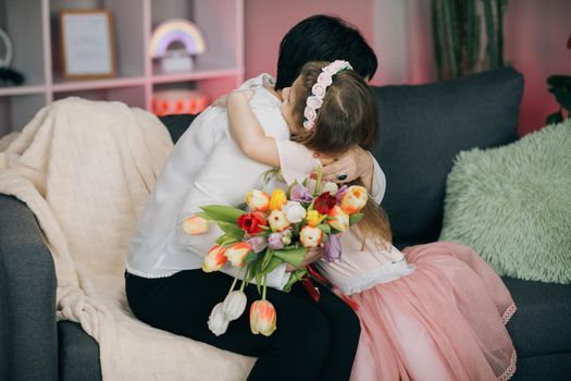 Happy Mother's Day Joy. Kissing and hugging happy family. Beautiful Mother And her little daughter. Smiling Caucasian Senior Mother with her Adult Daughter Hugging and Kisses in Mother's Day