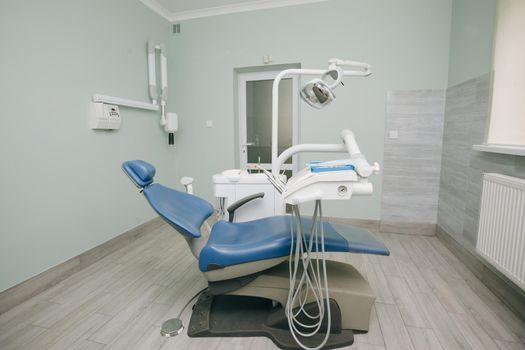 Modern dental practice. Dental chair and other accessories used by dentists in blue, medic light. Dentist Office, Dental Hygiene, Dentist's Chair.