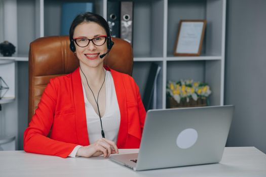 Woman wear headset communicating by conference call speak looking at camera at home office. Video chat job interview or distance language course class with online teacher concept.