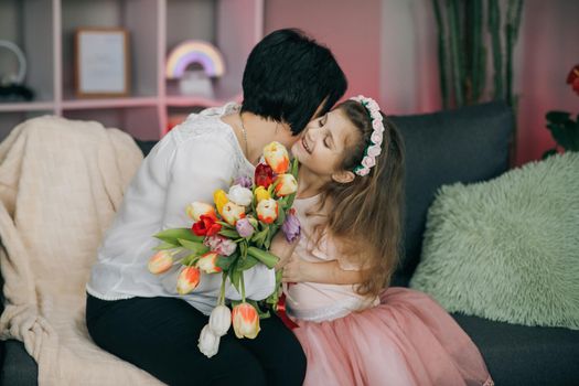 Happy Mother's Day Joy. Kissing and hugging happy family. Beautiful Mother And her little daughter. Smiling Caucasian Senior Mother with her Adult Daughter Hugging and Kisses in Mother's Day.