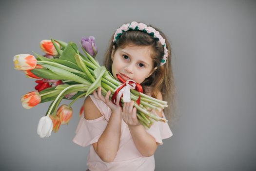 Attractive girl holding a bouquet of tulips in her hands. Women's or Mothers day