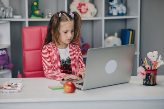 Distance learning online education. Schoolgirl with laptop notebook and doing school homework.