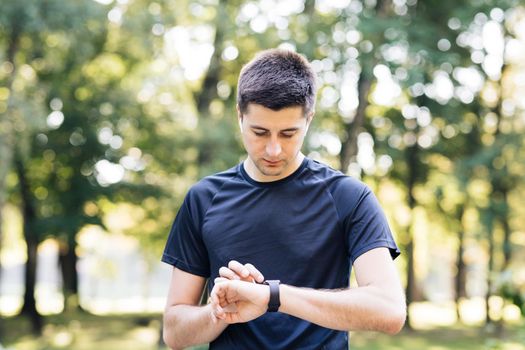 Caucasian man in sports uniform using smartwatch to measure speed, distance, heartbeet caring about physical body health. Futuristic technology. Mock up.