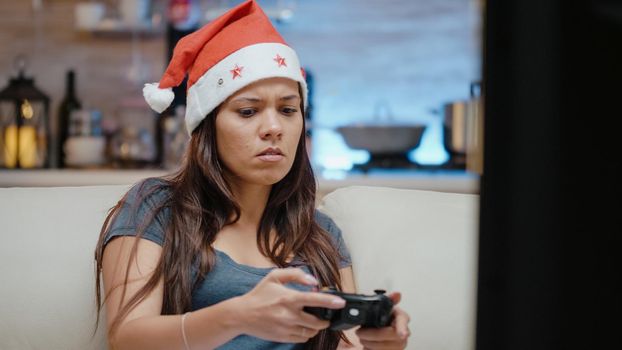 Close up of woman losing at video games on tv console with controller. Irritated person playing games with joystick on christmas eve to celebrate winter holiday with technology.