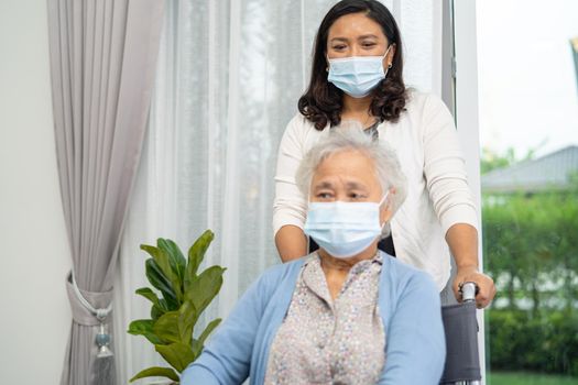 Help Asian senior or elderly old lady woman sitting on wheelchair and wearing a face mask for protect safety infection Covid-19 Coronavirus.