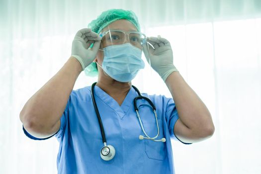 Asian doctor wearing mask, face shield and PPE suit new normal isolated on white background with clipping path to protect safety infection Covid-19 Coronavirus.