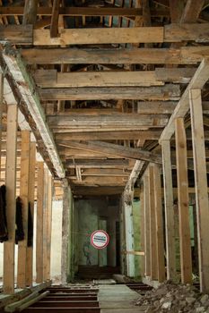 Old wrecked house with 'Danger' in English and in Ukrainian warning sign, abandoned building, uninhabitable place.