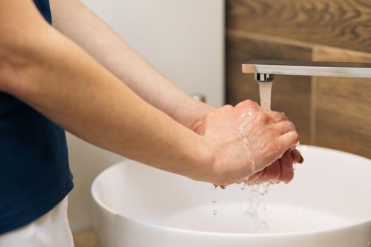 Hands of woman wash their hands in a sink to wash the skin the hands. Wash hands with soap warm water rubbing fingers washing frequently or using hand sanitizer gel. Coronavirus pandemic prevention.
