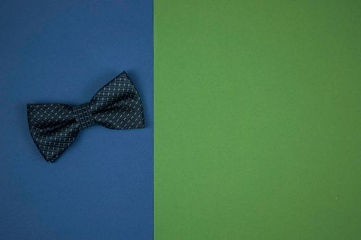 a bow tie lies on a green-blue background. A place to copy. Top view. Close-up, copy space, background. Father's Day concept, postcard