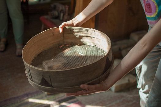 Old sieves, tool for bakery from the past for flour sifting in female hands.