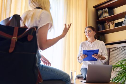 Session of female psychologist and girl teenage student in doctor's office. Consultation, professional assistance of terapist counselor for children and adolescents. Psychology, therapy, psychotherapy