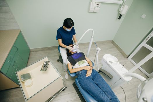 Dentist doing teeth whitening procedure with ultraviolet lamp. Concept of teeth care and dentistry. Led teeth whitening. Ultraviolet rays. lamp for teeth enamel whitening. Beautiful smile.
