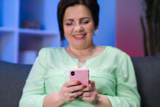 Hands Of Mature Woman Using Phone. Smartphone in the hands of an elderly person. Female in her 50s texting messages in social networks on smartphone, close-up