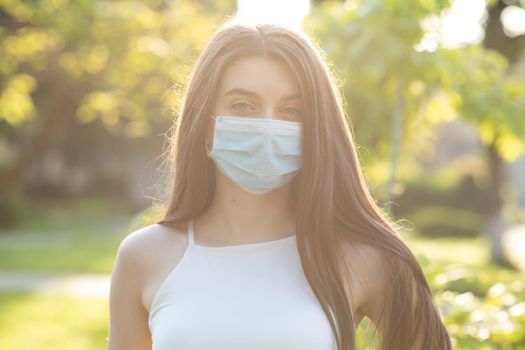 Close up portrait of a caucasian brunette in a protective medical mask on her face. The epidemic of influenza virus and coronavirus is everywhere.