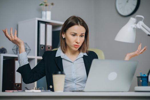 Business woman reading bad news on laptop computer at coworking space. Upset woman closing down laptop in office. Tired woman breathing deep at workplace. Business woman doing yoga exercise