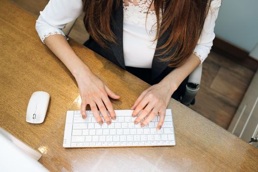 Business woman's hands typing on keyboard. Closeup of woman's hands touching keys trying to access data during work.