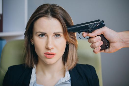 Serial killer holding a gun in his hand. Depression, failure, suicide.