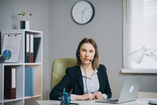 Portrait Woman in Headphones Holding Paper Financial Report talk at Webcam make video call in office, business coach looking at camera speak show statistics explain marketing strategy for client