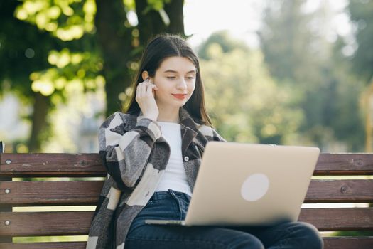 Young student watching lesson online and studying from park. College university student using laptop computer. Studying working with pc technology online education concept