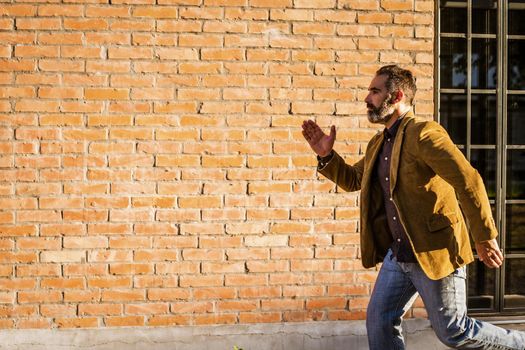 Modern businessman with beard running in a hurry on the street.