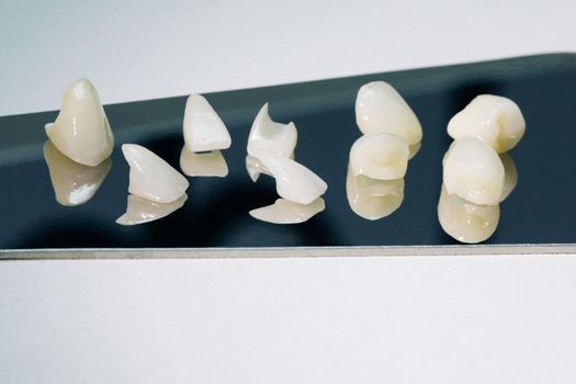Zirconium crowns veneers. Ceramic teeth with the veneers isolated on white background.