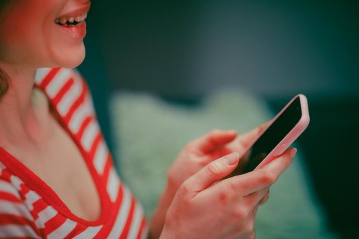 Woman Holding Smart Phone Looking at Cellphone Screen Laughing Enjoying Using Mobile Apps for Shopping. Having Fun Playing Games Chatting in Social Media Sit on Couch at Home