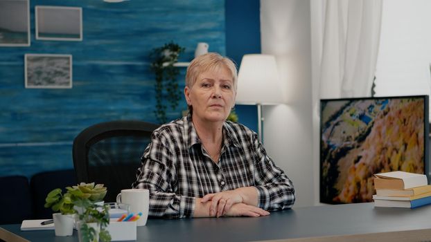 Portrait of senior woman talking and listening remote colleagues during video call, online conference, working from home. Person using online chat technology webcam making virtual meeting connection