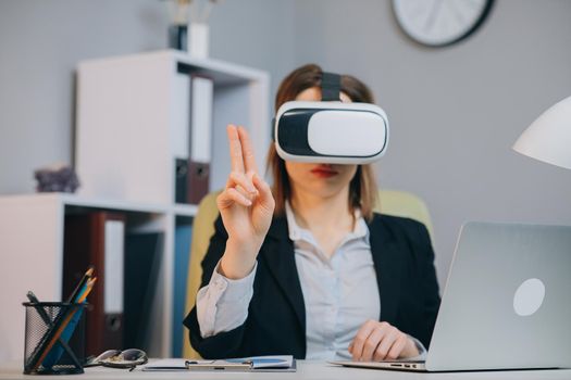 Caucasian female professional woman using augmented reality AR hololens headset to work on a project.