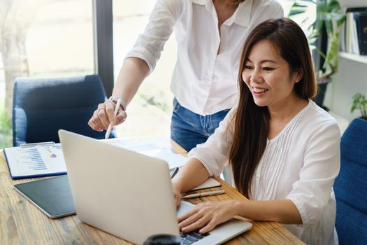 Adult woman teaching her friend to stock trading on laptop application. trade, stock, invest concept