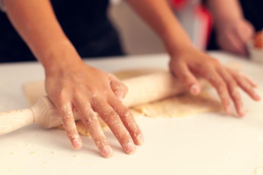 Granddaughter knead dough on christmas day. Happy cheerful joyfull teenage girl helping senior woman preparing sweet cookies to celebrate winter holidays.