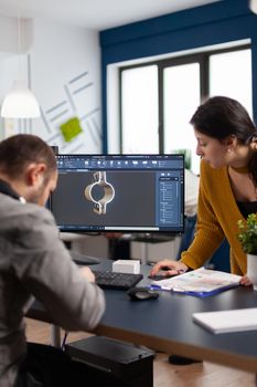 Coworkers engineer architects working on modern cad program developing construction metalic components. Industrial designer studying prototype idea on pc showing digital software with gears