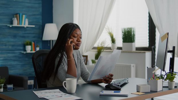 Upset sad student interacting with collegue explaining communication course using phone sitting at desk in living room. Young woman working at academic homework using elearning high school platform