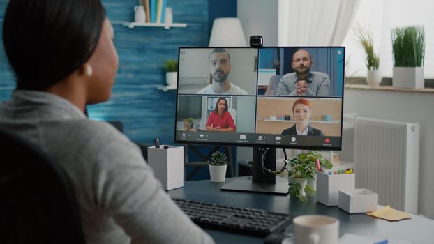 Black student waving high school team explaining marketing course discussing academic webinar during online videocall teleconference meeting. Overworked woman having virtual telework conference