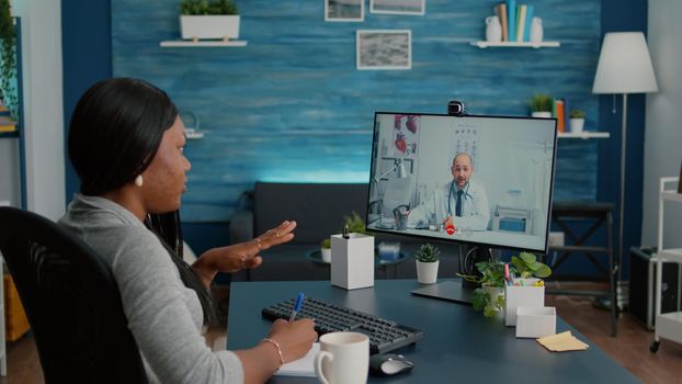 Sick student explaining respiratory treatment with therapist doctor during telemedicine healthcare appointment. Patient having online videocall conference discussing sickness symptoms in living room