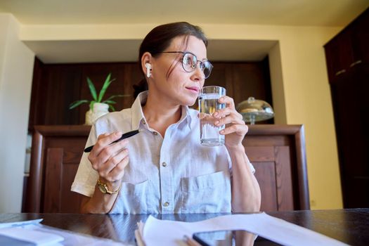 Portrait of businesswoman in headphones glasses looking at webcam, face close-up, home living room. Female talking online with clients, colleagues. Remote business, freelancing, technology in business