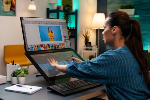 Studio editor doing retoucher work on touch screen computer monitor for occupation. Artist sitting at professional desk working with modern technology photography software and stylus