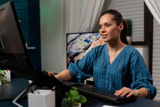 Creative editing artist using retoucher software on photo sitting at desk while working with photography editing equipment. Young woman retouching project on desktop monitor computer