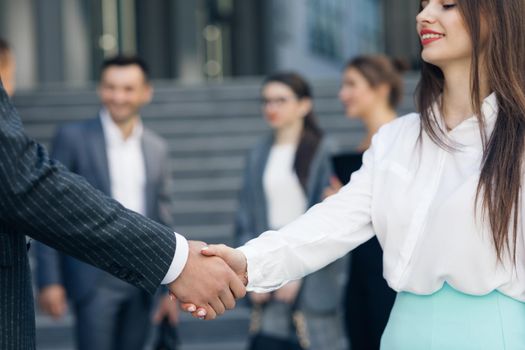 Friendly Handshake Man and Woman. Meeting of Two Business People outdoors. Unrecognizable couple Person Greeting Each Other. Multicultural Shaking Hands Closeup Shot